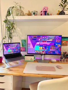 two computer monitors sitting next to each other on top of a wooden desk in front of a potted plant