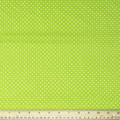 a ruler is next to a green polka dot fabric