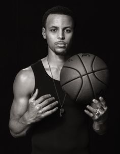 a black and white photo of a man holding a basketball in his hands with the ball on his chest