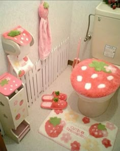 the bathroom is decorated in pink and has strawberry themed rugs on the floor next to the toilet