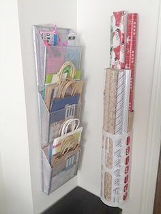 a stack of books and magazines hanging on a wall next to a door with wrapping paper