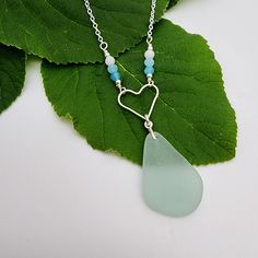 DESCRIPTION| Aqua sea glass dangles from a sterling silver heart in this charming pendant, accented by ombre gemstone beads. Perfect for any beach lover! DETAILS| Choose your preferred chain length from the drop-down Sterling silver components The pendant adds approximately 1.75" drop  Your purchase supports genuine, surf tumbled sea glass creations PLEASE NOTE| Coins are for scale only and not included in your purchase. Colors may appear different depending on screen settings, monitors & resolu Heart Charm Beach Jewelry, Heart Beads Necklace For Beach, Lover Jewelry, Glass Creations, Sterling Silver Heart Pendant, Silver Heart Pendant, Beach Lover, Sea Glass Necklace, Sterling Silver Heart