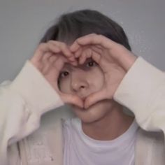 a person making a heart with their hands