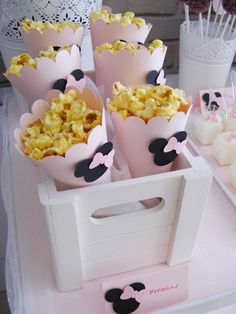 a table topped with lots of cupcakes covered in mickey mouse ears and marshmallows