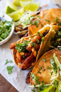 three tacos with meat, lettuce and other toppings