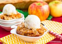 two bowls filled with apple crisp and ice cream on top of a yellow table cloth