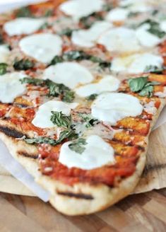 a close up of a pizza on a wooden cutting board