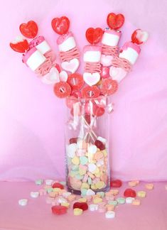 a vase filled with candy hearts and marshmallows