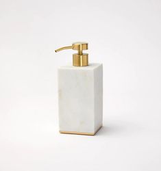 a white and gold soap dispenser on a white background