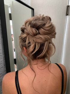 the back of a woman's head, with her hair in a low bun