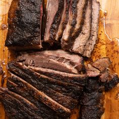 sliced up meat sitting on top of a wooden cutting board