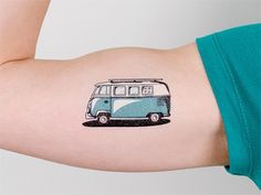 a small blue and white bus tattoo on the right side of the left arm,