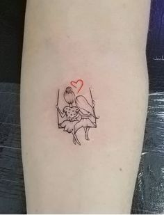 a small tattoo on the arm of a girl with a heart in her hand and a swing