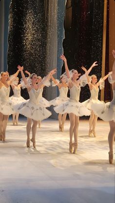 a group of ballerinas in white tutus and leorbets on stage