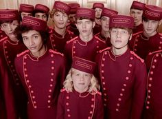 a group of young men and women wearing matching red uniforms