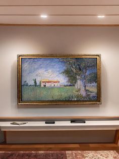 a painting hanging on the wall above a bench in a room with carpeted flooring