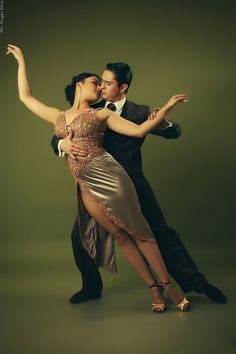 a man and woman are dancing together on a green background