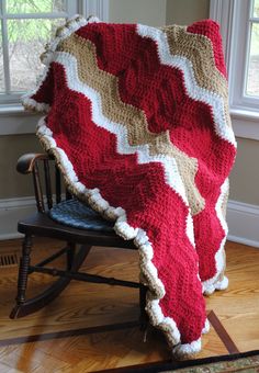 a red and white blanket sitting on top of a rocking chair