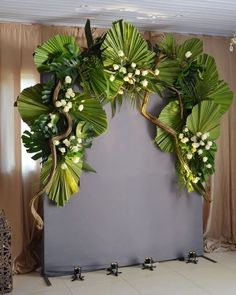 a large green plant with white flowers on it's head is hanging from the ceiling