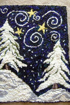 a close up of a piece of cloth with snow on it and trees in the background