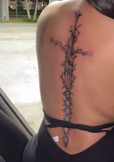 a woman with a cross tattoo on her back