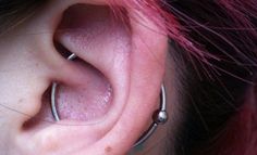 a close up of a persons ear with two piercings