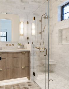 a bathroom with a walk in shower next to a sink and a large mirror on the wall