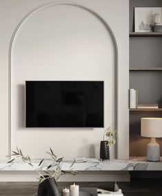 a flat screen tv mounted to the side of a white wall in a living room