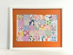 an orange and white framed artwork hanging on a wall