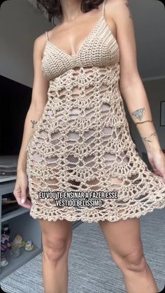 a woman in a crochet dress posing for the camera