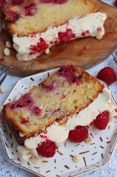 two slices of cake on plates with raspberries