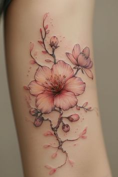 a woman's stomach with pink flowers on the side and behind her is a tattoo