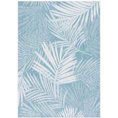 a blue and white rug with palm leaves on it