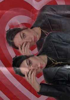 two people standing next to each other in front of a heart shaped background with the same person talking on their cell phone