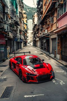 a red sports car parked on the side of a road in front of tall buildings