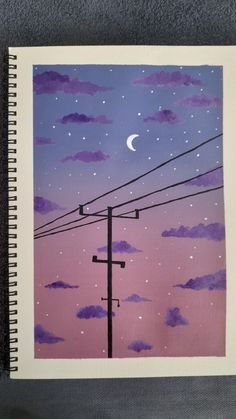 a notebook with an image of power lines and the moon in the sky