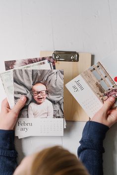 a person holding up some photos on a desk