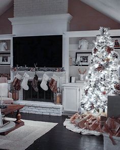 a living room with a christmas tree and stockings hanging from the fireplace mantels