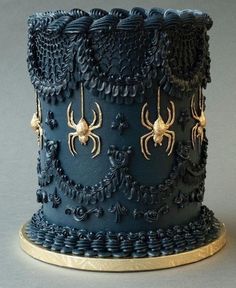 a blue cake with gold spider decorations on it