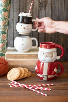 two mugs with santa clause and candy canes in front of them on a table