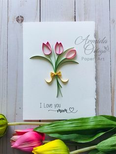 a card with some flowers on it and the words i love you mom written in gold