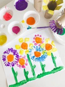 a child's art project with flowers painted on paper