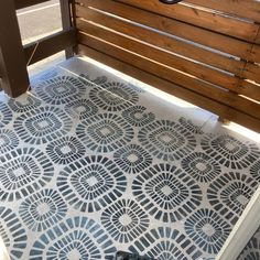 a phone is sitting on the ground next to a wooden bench with an intricate pattern