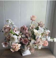 a vase filled with lots of pink and white flowers