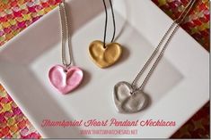 three heart shaped pendants on a white plate