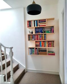 the bookshelf is made out of wood and has many different colored books on it