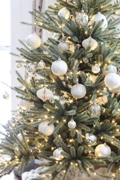 a christmas tree with white and silver ornaments