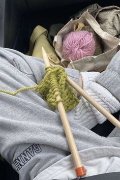 the knitting needles are next to yarn and crochet hooks in a box