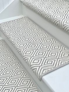 the stair treads are made from white and grey fabric with diamond pattern on them