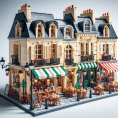 a lego model of a restaurant with tables and chairs in front of the storefront